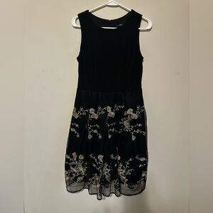 Elegant black cocktail dress featuring gold floral embroidery,